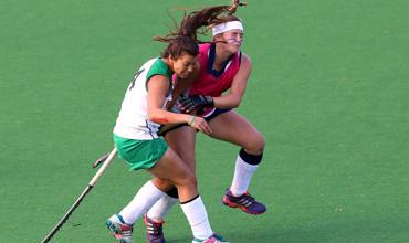 Camogie player striking the sliotar