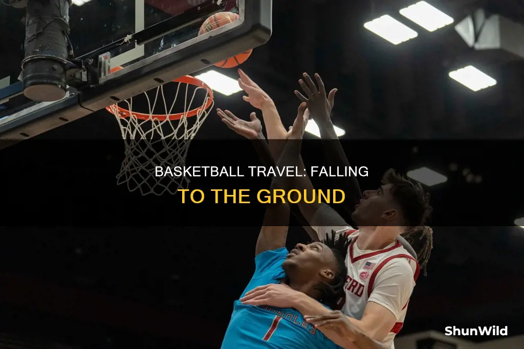 is falling to the ground with a basketball traveling