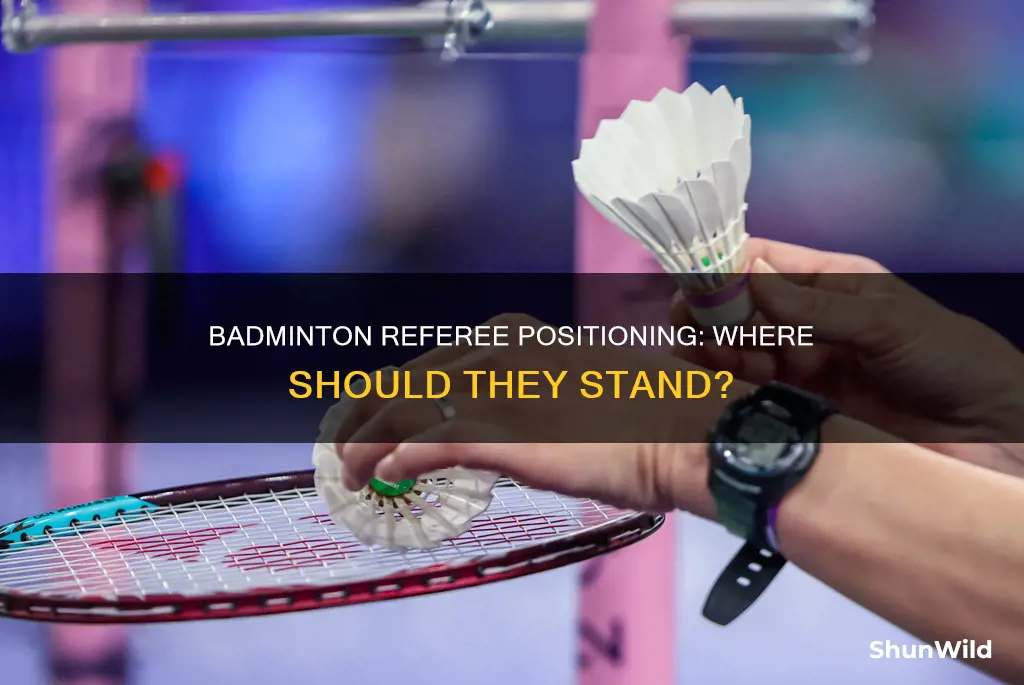 where does the referee stand in badminton